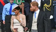 Duke dan Duchess of Sussex, Pangeran Harry dan Meghan Markle menghadiri pesta kebun Istana Buckingham di London, Selasa (22/5). Meghan juga memakai stocking warna kulit, mengikuti cara berbusana Putri Inggris lainnya. (Dominic Lipinski/Pool Photo via AP)
