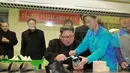 Pemimpin Korea Utara, Kim Jong-Un dibantu pekerja mengelem sepatu saat mengunjungi pabrik sepatu Wonsan, Korea Utara (3/12). (Photo by KCNA VIA KNS / various sources / AFP)