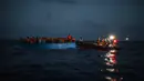 LSM Spanyol Open Arms menolong imigran di Laut Mediterania, Selasa (8/9/2020). Puluhan imigran termasuk wanita dan anak-anak asal Mesir, Maroko, Somalia, dan Sierra Leone menghabiskan lebih dari 20 jam saat melarikan diri dari Libya dengan kapal kayu. (AP Photo/Santi Palacios)