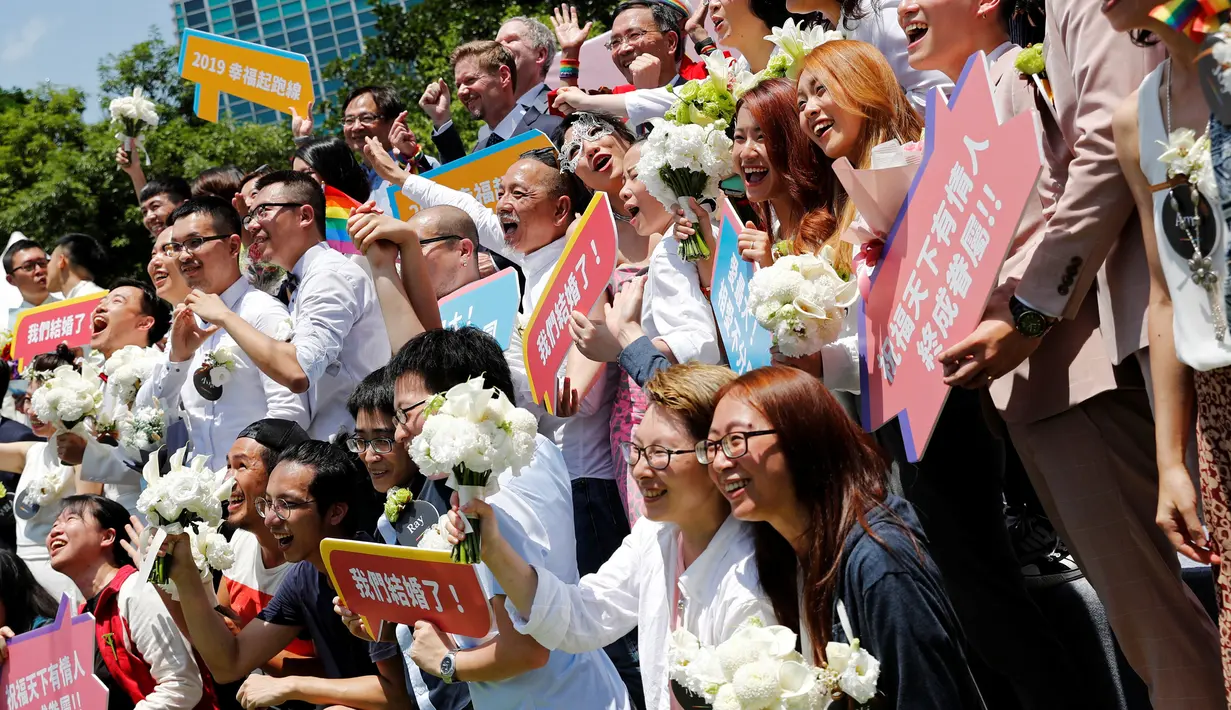 Pasangan gay dan lesbian berfoto bersama di pesta pernikahan sesama jenis di Taipei, Taiwan, Jumat (24/5/2019). Perayaan ini dianggap menjadi momentum kemenangan bagi kaum LGBT di Taiwan. (REUTERS/Tyrone Siu)