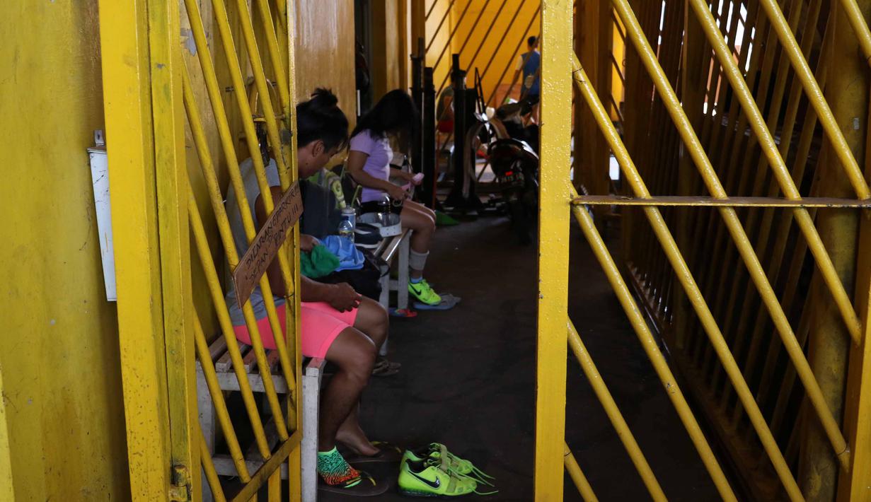 Atlet Angkat Besi Indonesia sedang bersiap untuk berlatih dekat halaman Parkir Angkat Besi di Senayan, Jakarta, Senin (11/1/2016). Hal ini karena tempat Latihan dalam tahap renovasi. (Bola.com/Nicklas Hanoatubun)