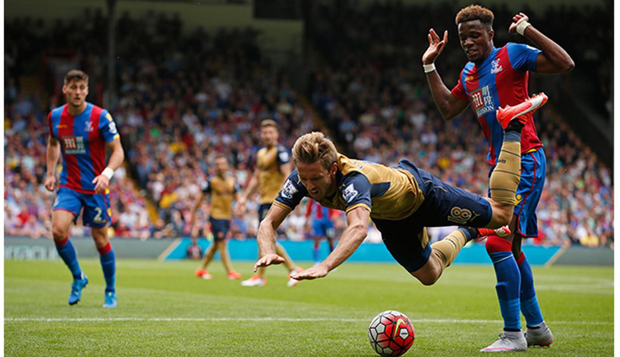 Pemain Crystal Palace, Wifried Zaha menjatuhkan pemain Arsenal, Nacho Monreal pada laga Liga Inggris di Stadion Selhurst Park, Inggris, Minggu (16/8/2015). Arsenal taklukan Palace 2-1. (Reuters/John Sibley)