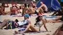 Turis mengenakan topi santa bermain ponsel selama  Hari Natal 2018 di Pantai Bondi di Sydney, Australia (25/12). (AFP Photo/Peter Parks)