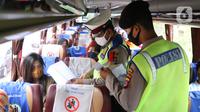Polisi memeriksa dokumen penumpang bus yang keluar Tol Merak, Banten, Senin (18/5/2020). Pemeriksaan (check point) tersebut terkait larangan mudik guna penyekatan atau memeriksa kemungkinan pemudik yang akan keluar dari wilayah Jabodetabek. (Liputan6.com/Angga Yuniar)
