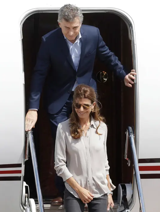 Presiden Argentina, Mauricio Macri (atas) bersama dan istrinya, Juliana Adawa, turun dari pesawat setibanya di Hamburg, Jerman, Kamis (6/7). Sejumlah kepala negara telah tiba di Hamburg jelang pembukaan KTT G20 pada 7-8 Juli 2017. (AP/Michael Sohn)