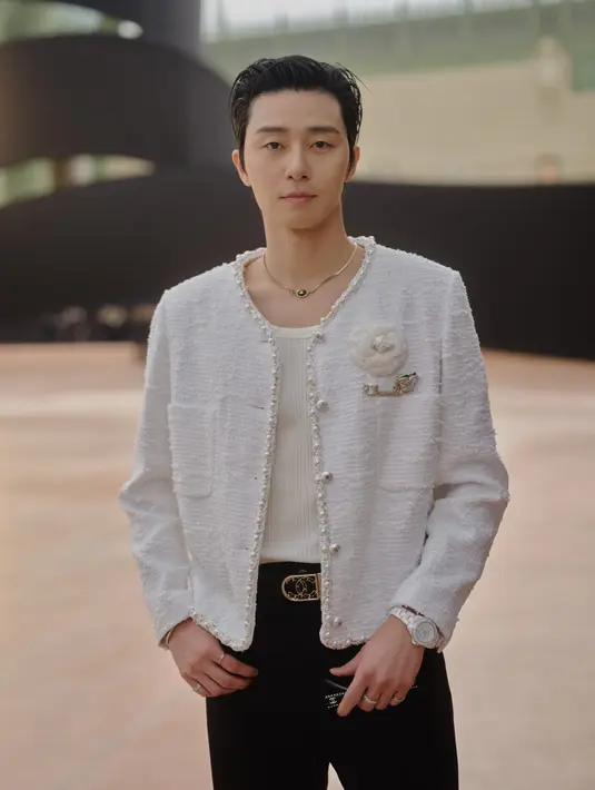 Park Seo Jun padukan sleeveless shirt dengan tweed jacket putih bertabur mutiara. Embellishment bunga Camelia khas Chanel menghiasi bagian dada sebelah kiri [Chanel]