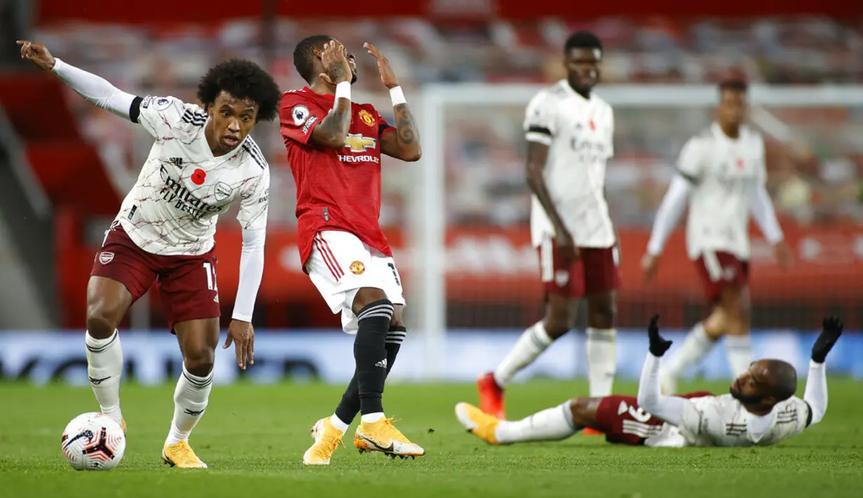 Pemain Arsenal Willian (kiri) menggiring bola saat pemain Manchester United Fred memberi isyarat pada pertandingan Liga Premier Inggris di Stadion Old Trafford, Manchester, Inggris, Minggu (1/11/2020). Arsenal menang 2-0. (Phil Noble/Pool via AP)