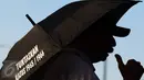 Aktivis JSKK membawa payung yang berisi kritikan saat aksi Kamisan ke-455 di depan Istana Negara, Jakarta (18/8). Aktivis berharap agar pemerintah segera mengambil langkah konkret penyelesaian kasus pelanggaran HAM. (Liputan6.com/Immanuel Antonius)