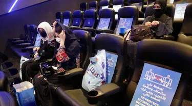 Perempuan Saudi mengenakan masker untuk mencegah penyebaran Covid-19 bersiap menyaksikan film di aula Bioskop VOX di Jiddah, Arab Saudi (26/6/2020). Pemerintah Arab Saudi membuka kembali bioskop setelah melonggarkan lockdown Covid-19. (AP Photo/Amr Nabil)