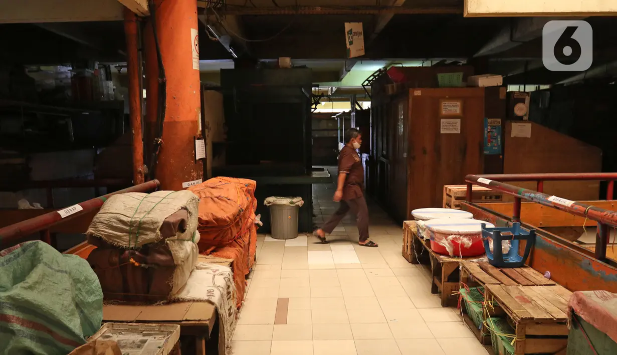Seorang pria melintas di area dalam Pasar Tomang Barat, Jakarta, Senin (29/06/2020). Pasar Tomang Barat atau yang lebih dikenal dengan sebutan Pasar Kopro itu ditutup mulai 29 Juni hingga 1 Juli setelah ada pedagang yang dinyatakan positif Covid-19 dari hasil tes usap. (Liputan6.com/Herman Zakharia)