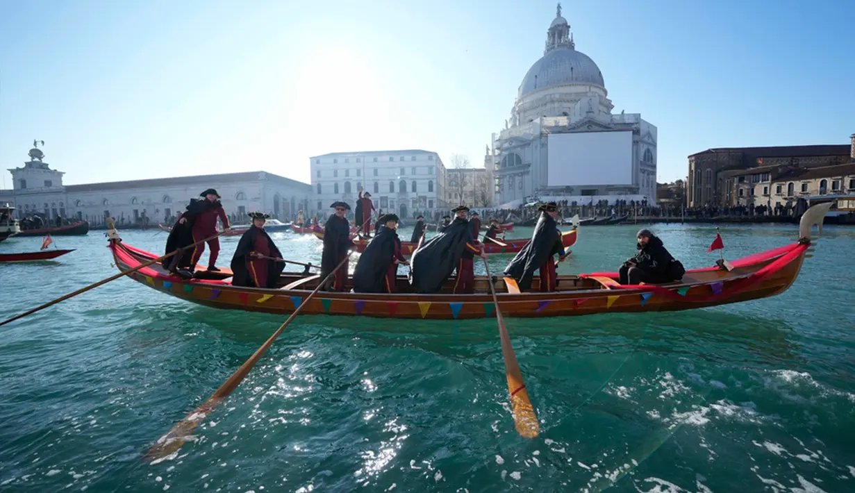 Perahu berlayar saat parade dayung tradisional, bagian dari Karnaval Venesia, di Venesia, Italia, Minggu (28/1/2024). (AP Photo/Luca Bruno)