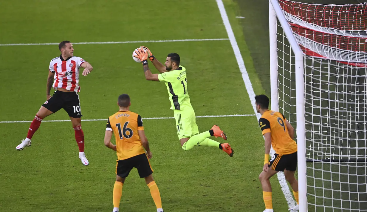 Kiper Wolverhampton Wanderers, Rui Patricio menangkap bola saat bertanding melawan Sheffield United pada pertandingan Liga Inggris di stadion Bramall Lane, Inggris, Senin, (14/9/2020). Wolves menang 2-0 atas Sheffield United. (Laurence Griffiths/Pool via AP)