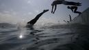 Perenang melompat ke air dalam lomba renang maraton internasiona di pantai Copacabana, Rio de Janeiro, Brazil. (Reuters/Ricardo Moraes)