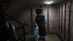 Seorang pria Yahudi ultra-Ortodoks dan putranya yang mengenakan kostum merayakan festival Yahudi Purim di sebuah sinagoga di Bnei Brak, Israel, Senin (6/3/2023). Purim tahun ini akan dimulai pada malam tanggal 6 Maret dan berlanjut hingga tanggal 7 Maret malam. (AP Photo/Oded Balilty)