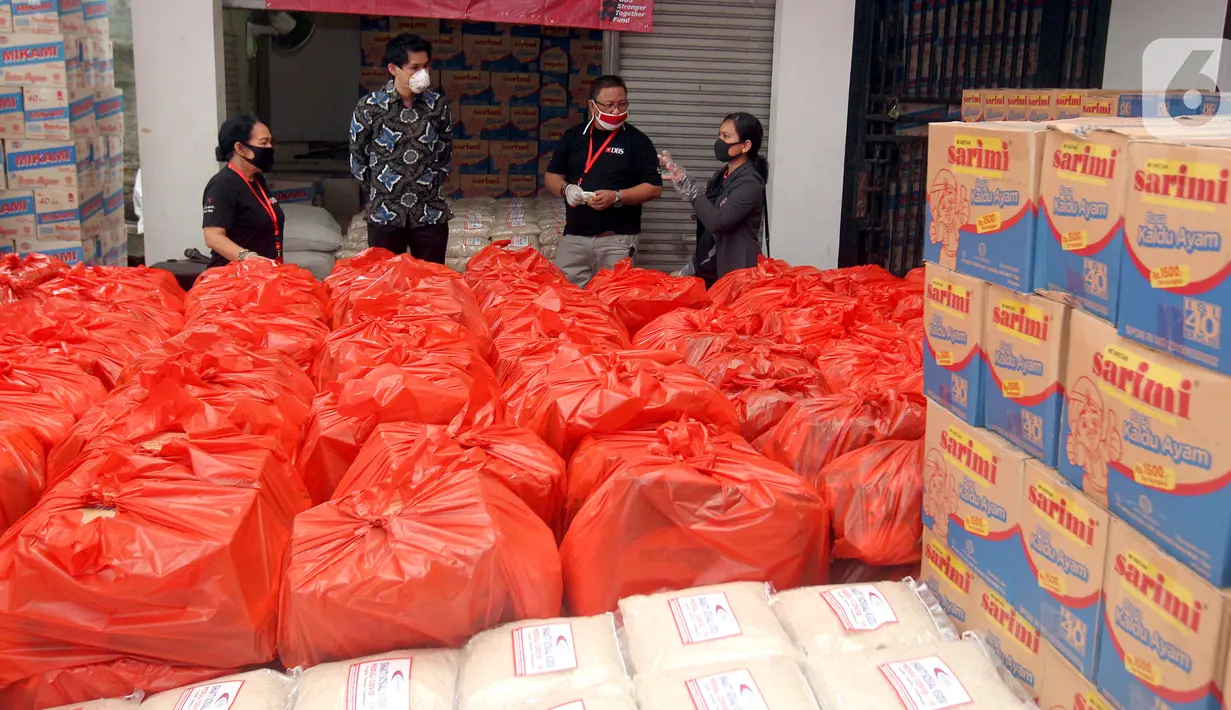 Pekerja harian lepas dan masyarakat terdampak COVID-19 menerima bantuan di Jakarta. Sebanyak 70.000 paket makanan disalurkan melalui KSBSI dan Founder of Foodbank of Indonesia yang dijembatani oleh Kedubes Singapura untuk Indonesia, Temasek Foundation dan Bank DBS Indonesia. (Liputan6.com/HO/Isa)
