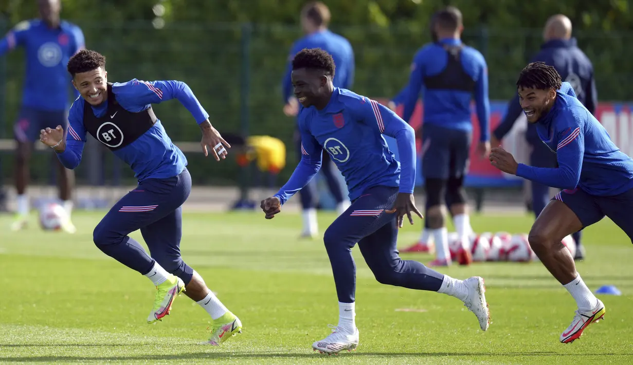 Penyerang Inggris, Jadon Sancho (kiri) bersama Bukayo Saka dan Tyrone Mings menghadiri sesi latihan di Hotspur Way Training Ground, Senin (11/10/2021). Inggris akan meladeni Hungaria dalam lanjutan Kualifikasi Piala Dunia 2022 zona Eropa Grup I pada Rabu, 13 Oktober 2021. (John Walton/PA via AP)