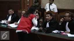 Jessica Kumala Wongso berdiskusi dengan kuasa hukumnya saat menjalani sidang perdana di PN Jakarta Pusat, Rabu (15/6). Dalam Sidang ini Jessica mengajukan eksepsi atau keberatan kepada majelis hakim. (Liputan6.com/Faizal Fanani)