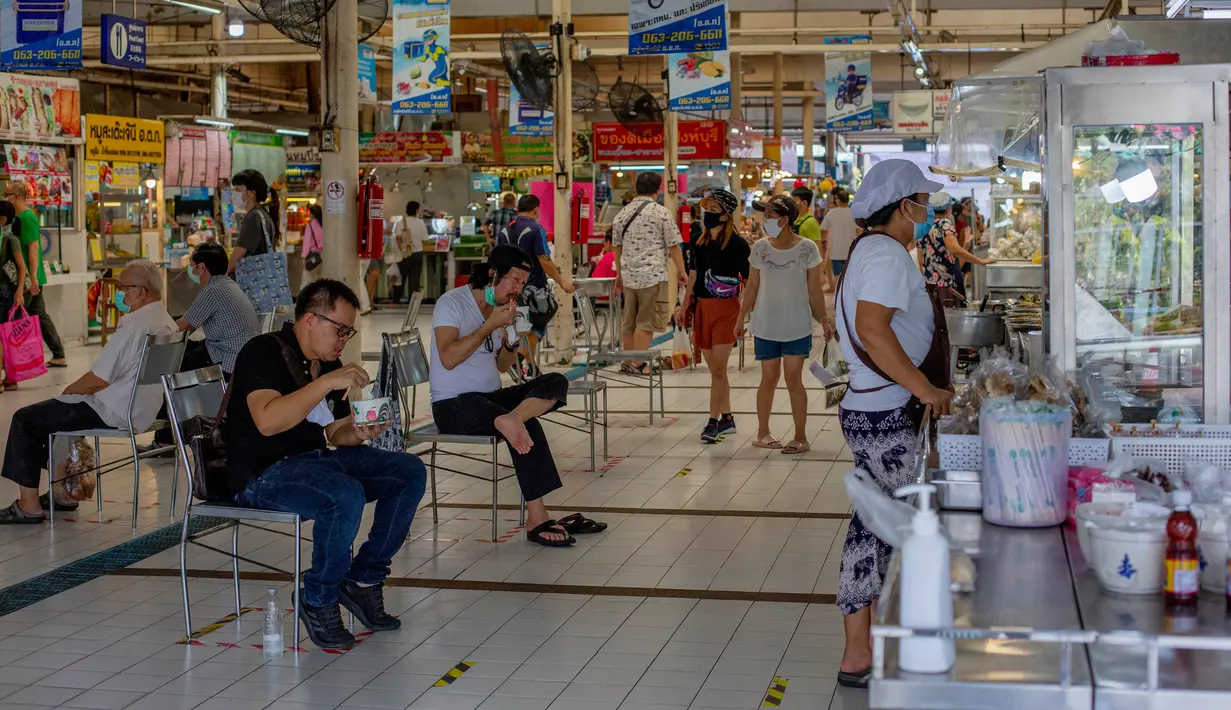 Orang-orang menjaga jarak sosial saat duduk menikmati makanan di sebuah pasar di Bangkok, Minggu (3/5/2020). Thailand mulai melonggarkan aturan pembatasan pergerakan orang dan pertemuan setelah diberlakukan beberapa minggu lalu dalam upaya memerangi penyebaran COVID-19. (AP/Gemunu Amarasinghe)