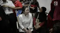 Menko PMK, Puan Maharani berbincang dengan salah satu pemudik di dalam kereta sebelum keberangkatan di Stasiun Senen, Jakarta, Rabu (21/6). Puan juga menggunakan topi kepala stasiun untuk menandai keberangkatan kereta. (Liputan6.com/Faizal Fanani)