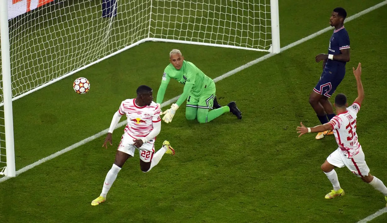 Pemain RB Leipzig Nordi Mukiele (kiri) melakukan selebrasi usai mencetak gol ke gawang Paris Saint-Germain yang dijaga Keylor Navas (tengah) pada pertandingan sepak bola Grup A Liga Champions di Stadion Parc des Princes, Paris, Prancis, Selasa (19/10/2021). PSG menang 3-2. (AP Photo/Christophe Ena)