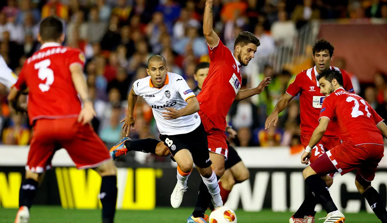 Gelandang Valencia, Sofiane Feghouli mencoba lolos dari kepungan pemain Sevilla saat berlaga di semifinal kedua Liga Europa di Stadion Mestalla, Valencia (2/5/2014). (REUTERS/Heino Kalis)  