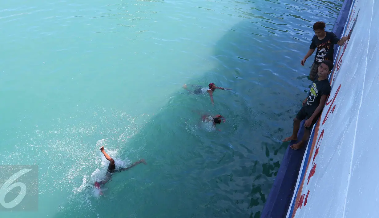 Sejumlah anak menceburkan diri ke laut untuk memburu koin yang dilemparkan penumpang dari atas kapal di Pelabuhan Merak, Banten, Jumat (26/8). Aksi itu menjadi hiburan bagi penumpang yang akan menyeberang ke Pulau Sumatera. (Liputan6.com/Angga Yuniar)