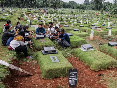Sejumlah orang saat berziarah ke makam di Tempat Pemakaman Umum (TPU) Pondok Ranggon, Jakarta, Minggu (04/04/21). Menjelang bulan Ramadan umat muslim melakukan ziarah kubur untuk mendoakan keluarga dan kerabatnya yang telah wafat. (Liputan6.com/Faizal Fanani)