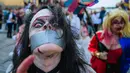 Seorang pria menggunakan kostum seperti zombie berjalan di tengah kota dalam parade "Zombie Walk" di Stockholm, Swedia, Sabtu (19/8). Zombie Walk adalah acara yang rutin dilakukan saat musim panas tiba, tepatnya akhir Agustus. (Jonathan NACKSTRAND/AFP)