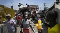 Penduduk setempat memuat kasur di atap bus di pasar Petion-Ville di Port-au-Prince, empat hari setelah pembunuhan Presiden Haiti Jovenel Moise, Minggu (11/7/2021). Moïse tewas dibunuh dalam serangan di kediaman pribadinya, pada Rabu 7 Juli 2021 dini hari. (AP Photo/Matias Delacroix)