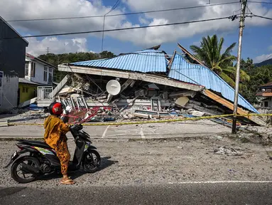 Sebuah sepeda motor berhenti di dekat bangunan yang runtuh pascagempa berkekuatan magnitudo 7,7 di Borong, Manggarai Timur, Nusa Tenggara Timur, Minggu, 16 Agustus 2026.. (AFP/ Juni Kriswanto)