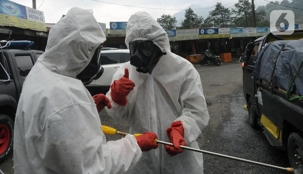 Anggota Batalyon B Brimob Cipanas melakukan penyemprotan disinfektan saat penyekatan arus lalu lintas di kawasan Ciloto, Cianjur, Jawa Barat, Jumat (17/4/2020). Penyemprotan yang dilakukan selama 20 hari tanpa henti ini untuk mencegah penyebaran virus corona COVID-19. (merdeka.com/Arie Basuki)