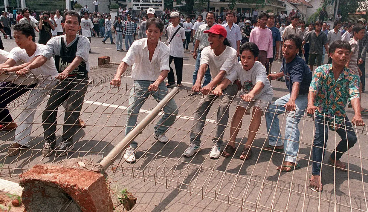 Para mahasiswa merusak pagar kampus mereka untuk bisa keluar dan menggelar unjuk rasa anti-pemerintah pada 14 Mei 1998. Bulan Mei 1998 merupakan momen penting dalam sejarah Indonesia, juga momen penting bagi Soeharto. (KEMAL JUFRI/AFP)
