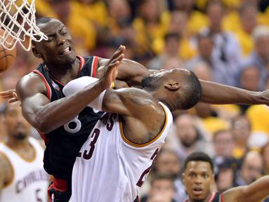 Pemain Cleveland Cavaliers, LeBron James, dihadang pemain Toronto Raptors, Bismack Biyombo, pada Final Wilayah Timur, NBA Playoffs 2016 di Quicken Loans Arena, Cleveland, Rabu (18/5/2016) WIB. Cavaliers menang 115-84. (Ken Blaze-USA TODAY Sports/Reuters)