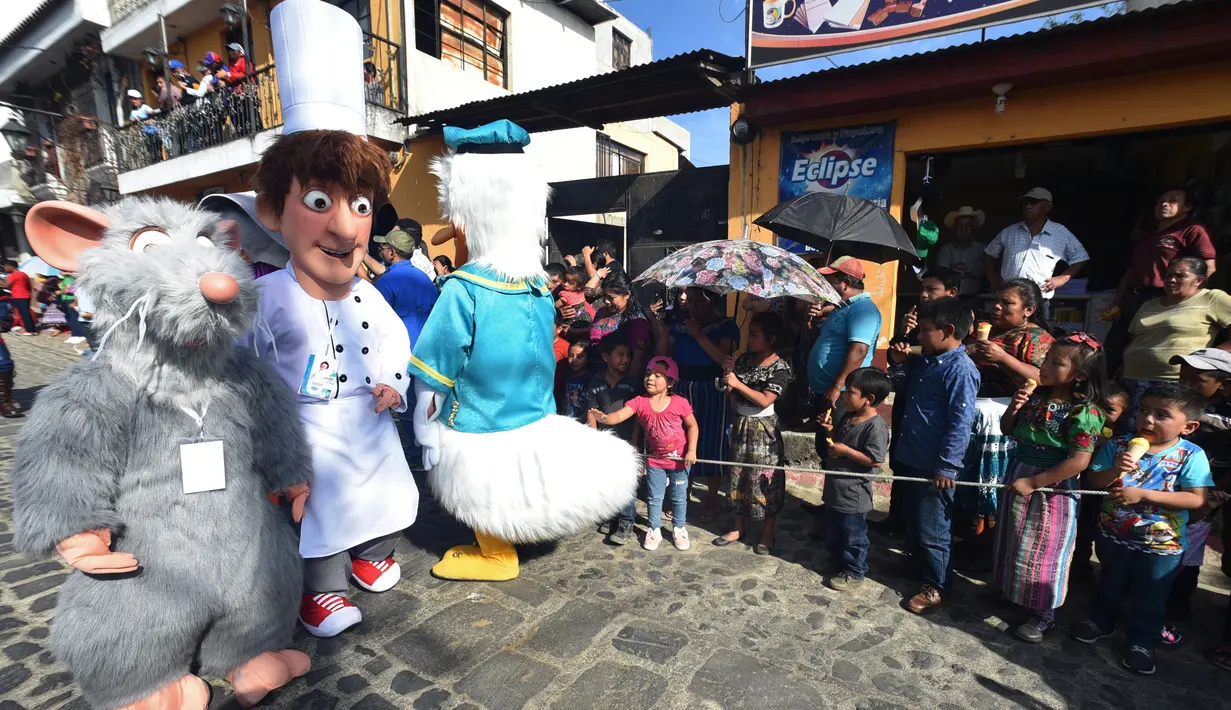 Anggota Saturno Club dengan kostum Ratatouille Remy dan Alfredo Linguini melakukan parade Dance of Costumes tahunan di Sumpango, Guatemala, Senin (30/12/2019). Parade kostum yang menampilkan karakter televisi dan film ini untuk memeriahkan malam pergantian tahun. (ORLANDO ESTRADA/AFP)