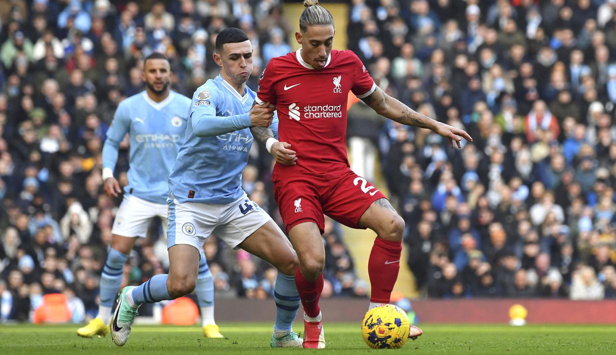 Bek Liverpool, Kostas Tsimikas (kanan) menguasai bola dibayangi gelandang Manchester City, Phil Foden pada laga pekan ke-13 Liga Inggris 2023/2024 di Etihad Stadium, Manchester, Sabtu (25/11/2023). (AP Photo/Rui Vieira)