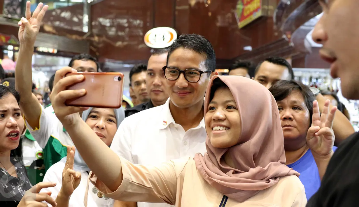 Seorang pedagang meminta foto bersama dengan Cawagub DKI Jakarta, Sandiaga Uno saat berkampanye di ITC Mangga Dua, Jakarta Utara, Kamis (3/11). Di ITC tersebut, Sandiaga menyempatkan diri mendengar keluh kesah para pedagang. (Liputan6.com/Gempur M Surya)