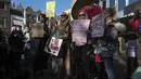 Para pekerja seks membawa plakat memprotes perlakuan dan stigma yang tidak setara selama demonstrasi di Den Haag, Belanda, Selasa (2/3/2021). Mereka berdemonstrasi di luar parlemen dalam protes terhadap penguncian keras virus corona oleh pemerintah. (AP Photo/Patrick Post)