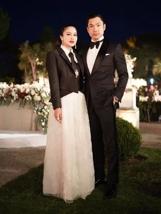 Vibes mahal dari gaya Sandra Dewi dan Harvey Moeis. Sandra Dewi tampil menawan dengan atasan kemeja putih ditumpuknya dengan cropped vest dan cropped blazer berwarna hitam, lengkap dengan dasinya. Penampilannya dipadu dengan rok panjang berwarna putih yang serasi. Sedangkan Harvey tampil dengan setelan jas dan celana panjang hitam, kemeja putih, dan dasi kupu-kupu hitamnya. [Foto: Instagram/sandradewi88]