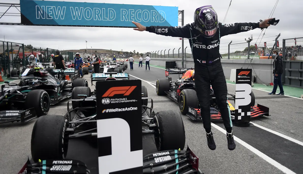 Pembalap Mercedes Lewis Hamilton melompat keluar dari mobilnya setelah memecahkan rekor kemenangan ke-92 di Formula 1 GP Portugaldi Algarve International Sirkuit, Portugal (25/10/2020). Berkat kemenangan itu, Hamilton mematahkan rekor milik Michael Schumacher. (Jorge Guerrero, Pool via AP)