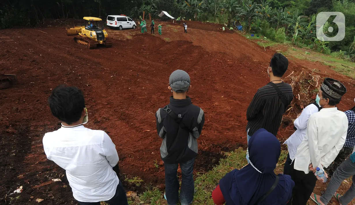 Petugas dengan alat berat meratakan tanah di belakang Blok AA-1 TPU Pondok Ranggon, Jakarta, Kamis (2/4/2020). Dinas Bina Marga Pemprov DKI melakukan pematangan atau perluasan lahan di TPU Pondok Ranggon untuk menangani permasalahan pemakaman korban corona Covid-19. (merdeka.com/Arie Basuki)