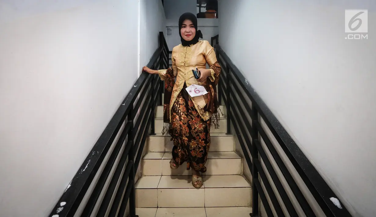 Seorang pengemudi ojek online wanita menuruni tangga jelang peragaan busana di Rawamangun, Jakarta, Jumat (20/4). Kegiatan digelar menyambut Hari Kartini yang jatuh pada 21 April mendatang. (Liputan6.com/Fery Pradolo)