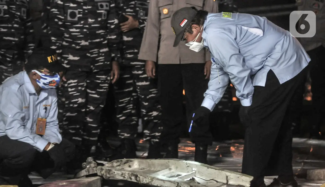 Tim KNKT mengidentifikasi serpihan pesawat Sriwijaya Air SJ 182 di Dermaga JICT 2, Tanjung Priok, Jakarta, Minggu (10/1/2021). Pencarian Sriwijaya Air SJ 182 tetap dilakukan pada malam hari meski secara terbatas. (merdeka.com/Iqbal S. Nugroho)