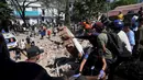 Sejumlah orang mencari korban yang tertimbun  bangunan yang runtuh akibat gempa bumi di Cali, Kolombia, Senin, 10 Agustus 2026 (AFP/ Joaquin Sarmiento)