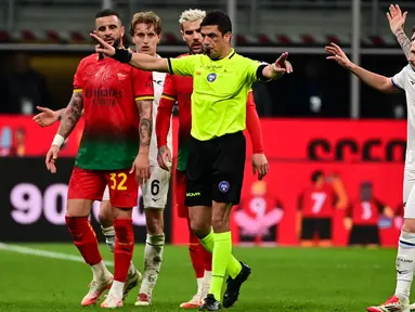 Wasit Gianluca Manganiello (tengah) memberi isyarat di samping bek AC Milan Kyle Walker (kiri) dan gelandang Lazio Manuel Lazzari saat pertandingan ke- 27 Serie A Italia 2024/2025 di stadion San Siro, Milan, pada Minggu 2 Maret 2025 waktu setempat atau Senin (3/3/2025) dini hari WIB. (Piero CRUCIATTI/AFP)