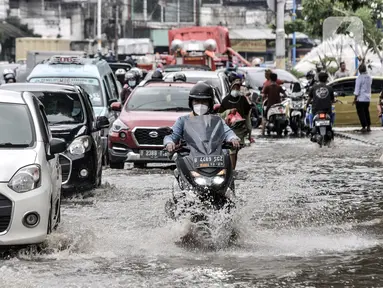 Sejumlah kendaraan terjebak kemacetan akibat banjir yang menggenangi Jalan Jatinegara Barat, Jakarta, Senin (8/2/2021). Banjir yang menggenangi Jalan Jatinegara Barat terjadi akibat luapan Kali Ciliwung yang dipicu hujan deras di Jakarta dan Bogor sejak dini hari tadi. (merdeka.com/Iqbal S. Nugroho)