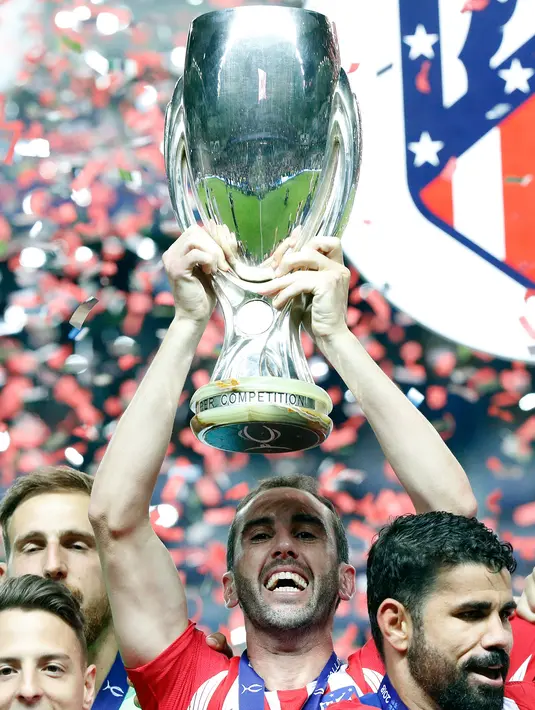 Kapten Atletico Madrid, Diego Godín mengangkat Piala Super Eropa usai pertandingan melewan Real Madrid di Lillekula Stadium di Tallinn, Estonia, (15/8). Atletico Madrid berhasil mengalahkan Real Madrid dengan skor telak 4-2. (AP Photo/Pavel Golovkin)