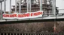 Seorang aktivis dari organisasi hak-hak perempuan Femen melakukan aksi bergelantungan dari sebuah jembatan di Paris, Prancis, Kamis (28/1). Ia menggelar protes atas kunjungan Presiden Iran, Hassan Rouhani ke Paris. (REUTERS/Charles Platiau)