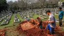 Petugas menggali tanah untuk makam almarhumah Ani Yudhoyono, istri Presiden Ke-6 RI yang berada di Blok M 129 Taman Makam Pahlawan (TMP) Kalibata, Jakarta, Sabtu, (01/6/2019). Ani Yudhoyono meninggal di National University Hospital (NUH) pada pukul 11.50 waktu Singapura. (Liputan6.com/Faizal Fanani)