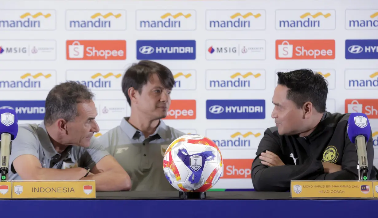 Pelatih Timnas Indonesia U-23 Gerald Vanenburg (kiri) berbincang dengan Mohd Nafuzi Bin Muhammad Zain (Malaysia) saat menghadiri sesi keterangan resmi jelang laga ASEAN U23 Championship 2025 di Stadion Utama Gelora Bung Karno, Jakarta pada Senin (14/7/2025). (Bola.com/Abdul Aziz)