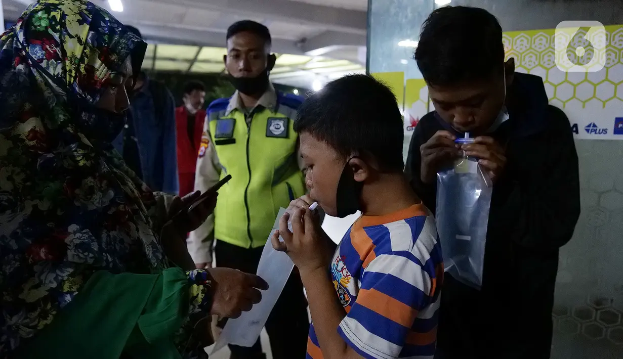 Calon penumpang kapal ferry meniup kantung saat menjalani tes deteksi COVID-19 dengan GeNose C19 di Pelabuhan Merak, Banten, Rabu (5/5/2021) dinihari. Pelabuhan Merak mewajibkan para penumpang kapal ferry menjalani tes GeNose C19 untuk mencegah penyebaran COVID-19. (Liputan6.com/Herman Zakharia)